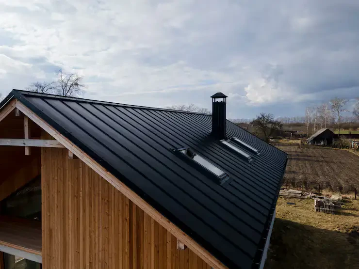 Completed dark metal roof on a timber-clad building