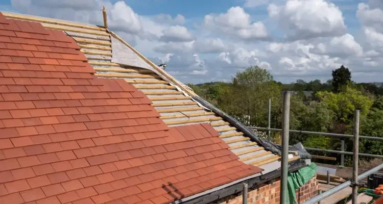 Roof replacement in progress with terracotta tiles and new battens