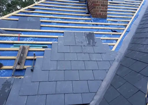 Slate roof replacement in progress with new membrane and battens
