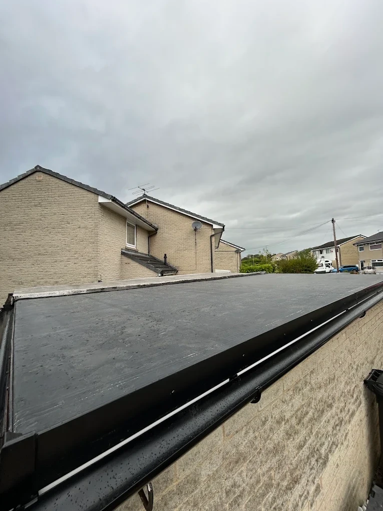 Finished flat roof on a low stone building with neat edge trims
