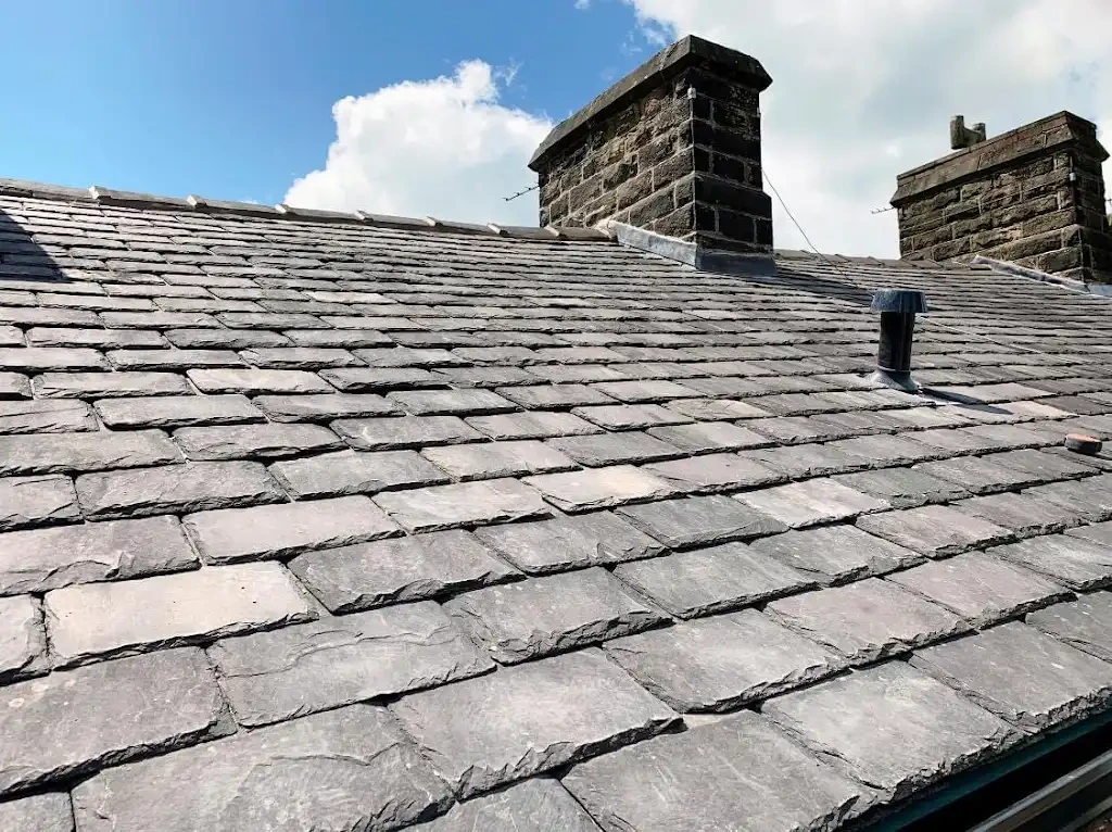 Slate roof replacement with two stone chimney stacks in Lancashire