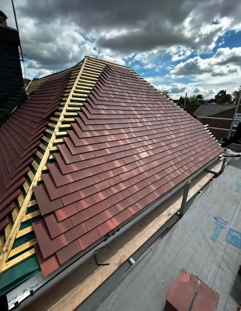 Roof being re-tiled with terracotta tiles over new battens